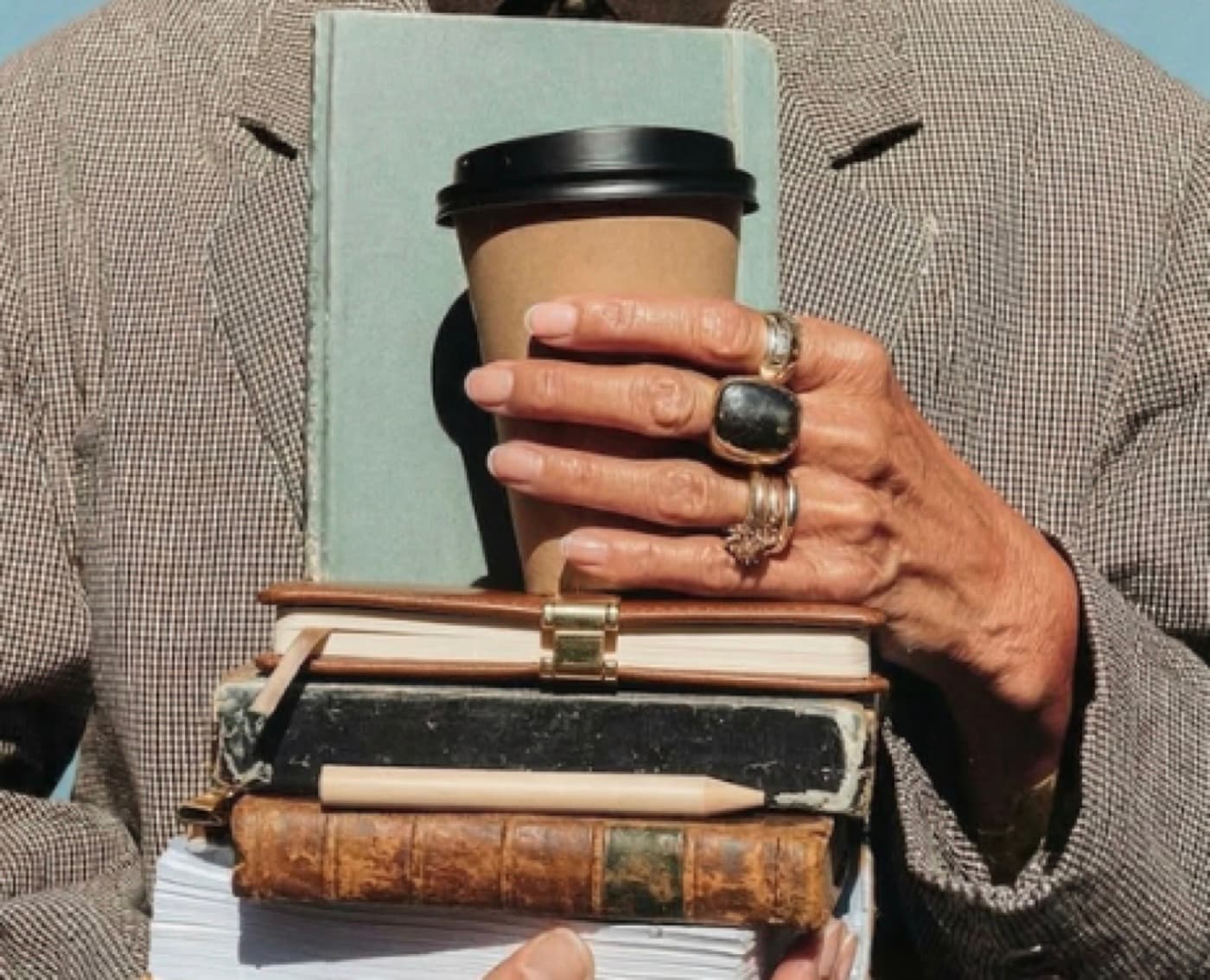 Un docente con una pila di libri e un caffè