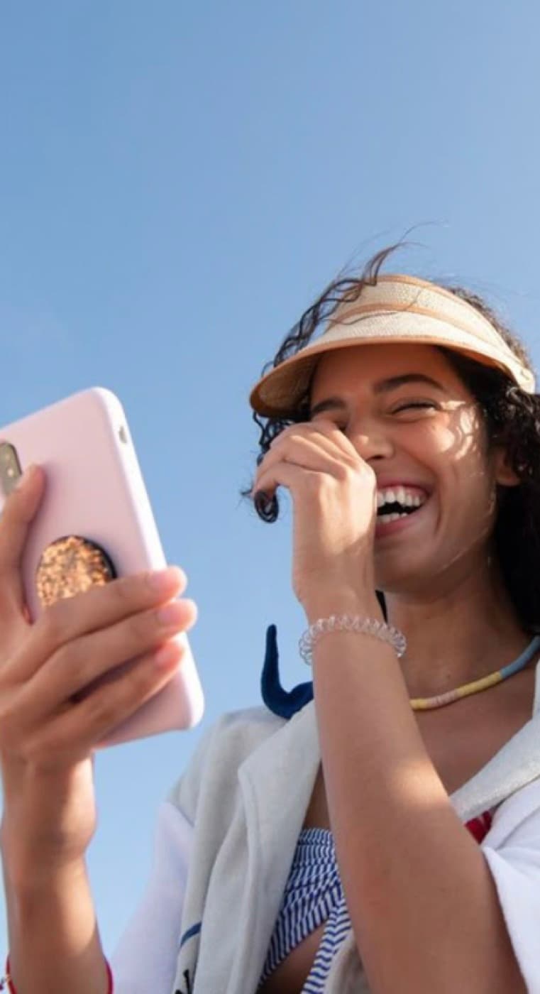 Una studentessa ride guardando il telefono